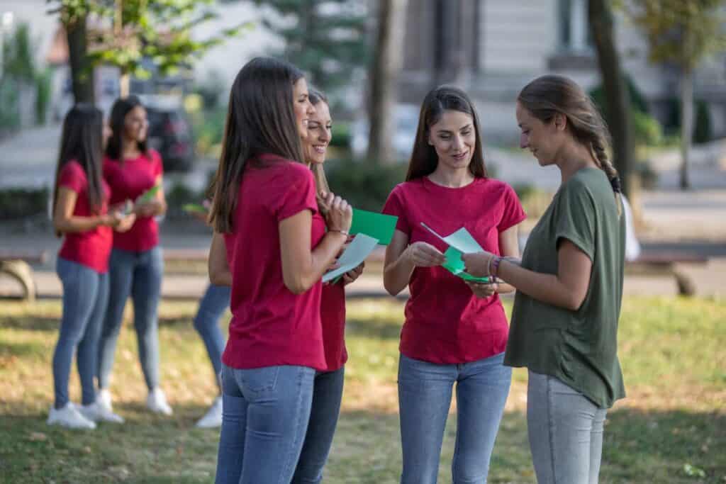 where-to-advertise-dog-walking-methods Image of a group of women passing out flyers to prospective dog walking clients.
